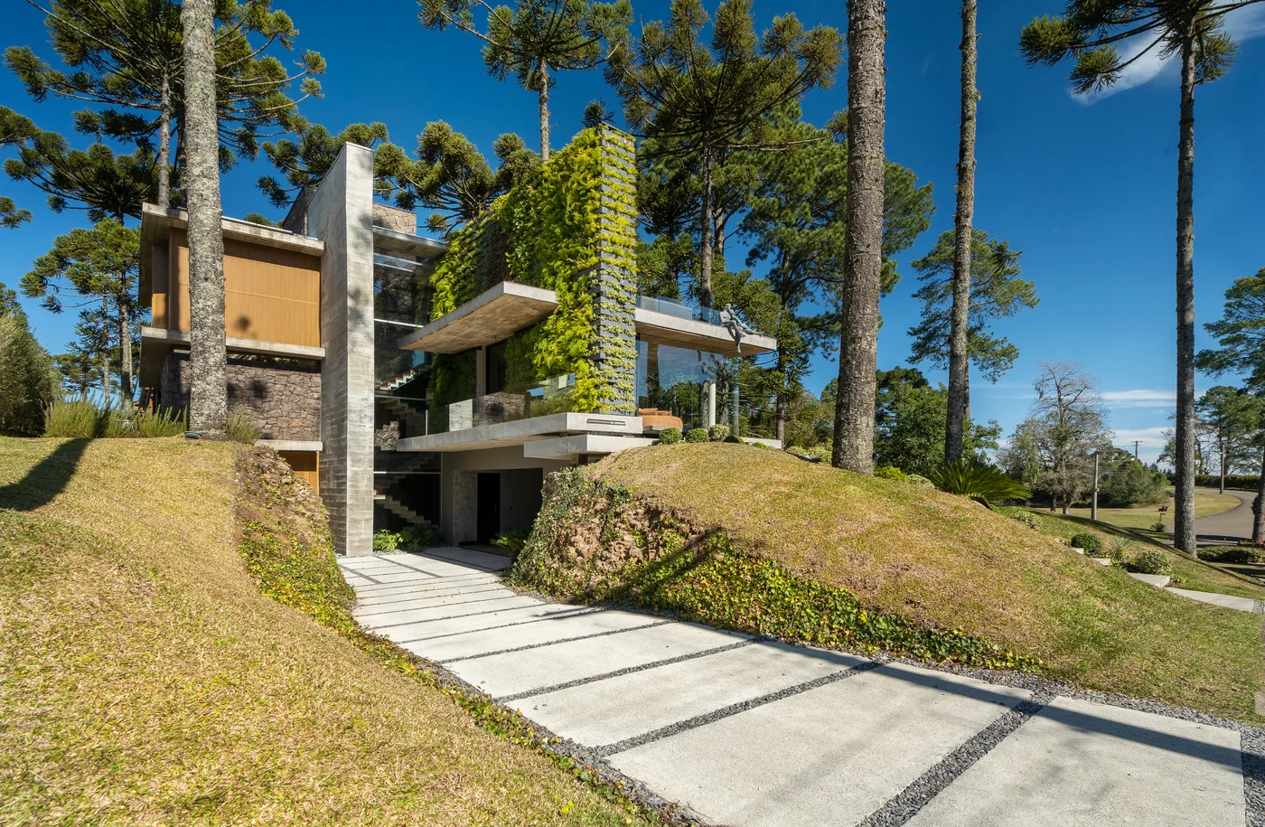 Fachada de casa moderna en ladera con jardín vertical
